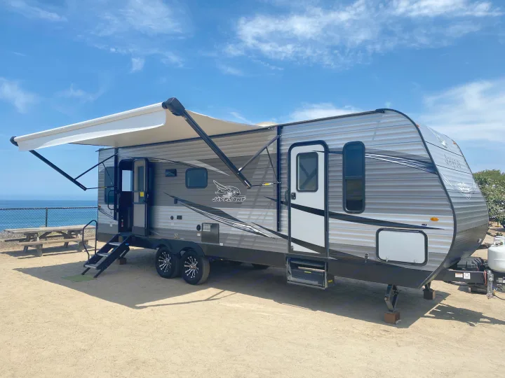This grey Jayco Jay Flight RV rental, complete with an extended awning and steps, offers a fantastic oceanfront camping experience.. Jayco Jay Flight 2020