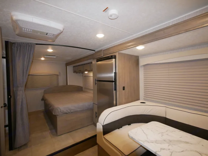 Modern RV rental interior featuring a cozy bedroom, comfortable U-shaped dinette, and well-equipped living space.. Coachmen Freelander 23FS 2022