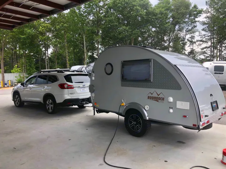White Subaru SUV hitched to a gray "Boondock Lite" teardrop trailer, perfect for your rv rental getaway.. T@B T@B 320 OffRoad 2020