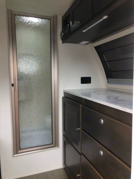 Experience RV rental comfort: a frosted glass shower, dark cabinetry, and sleek marble-look counter within a compact space.. T@B T@B 320 OffRoad 2020