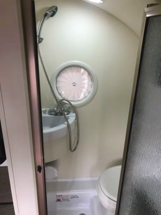 RV rental wet bath: compact shower, sink, and toilet with a unique round window.. T@B T@B 320 OffRoad 2020