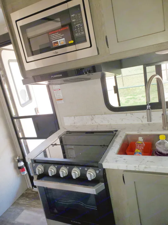 This RV rental features a functional kitchen with a High Pointe microwave, Furrion stove, and sink. Ready for your adventure.. Keystone Outback 2020