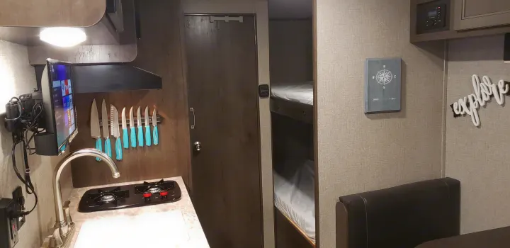Cozy RV rental interior featuring kitchen, bunk beds, and dining area. Perfect for travel adventures.. Jayco Jay Flight 2021
