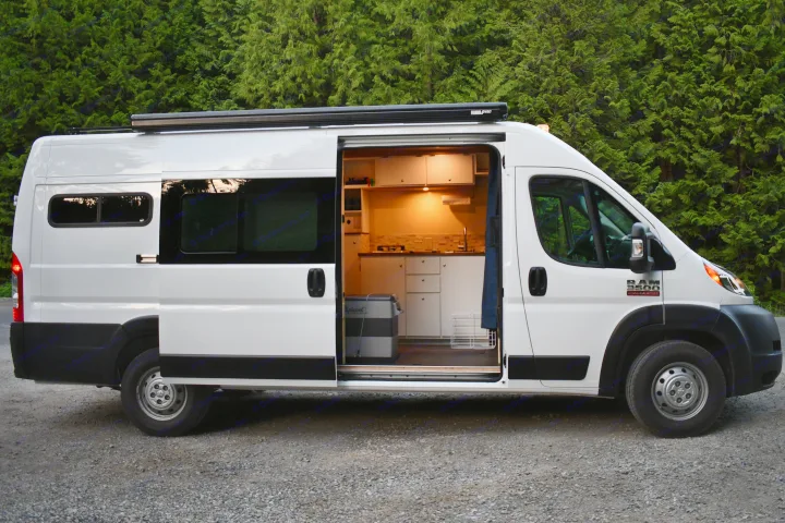White Ram ProMaster camper van, side door open to illuminated kitchen interior. Explore with this RV rental.. Other Other 2021