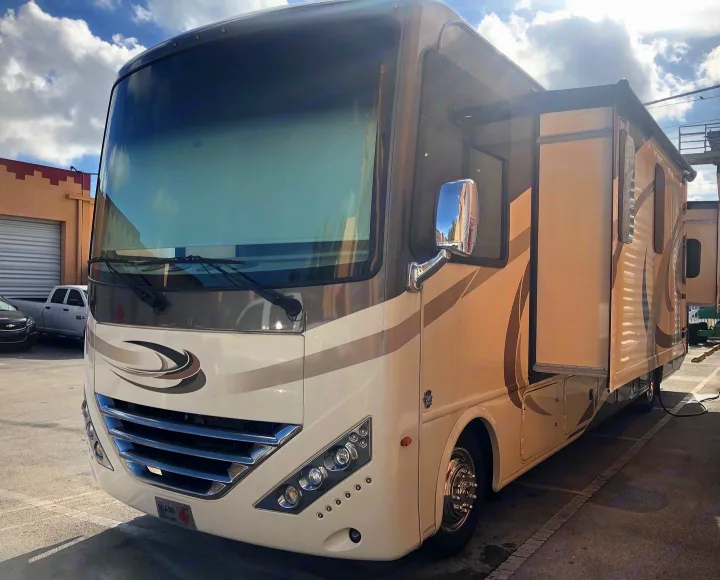 Spacious, modern cream and tan RV rental with extended slide-out, parked outdoors. Ideal motorhome for your adventure.. Holiday Rambler Vacationer 2018