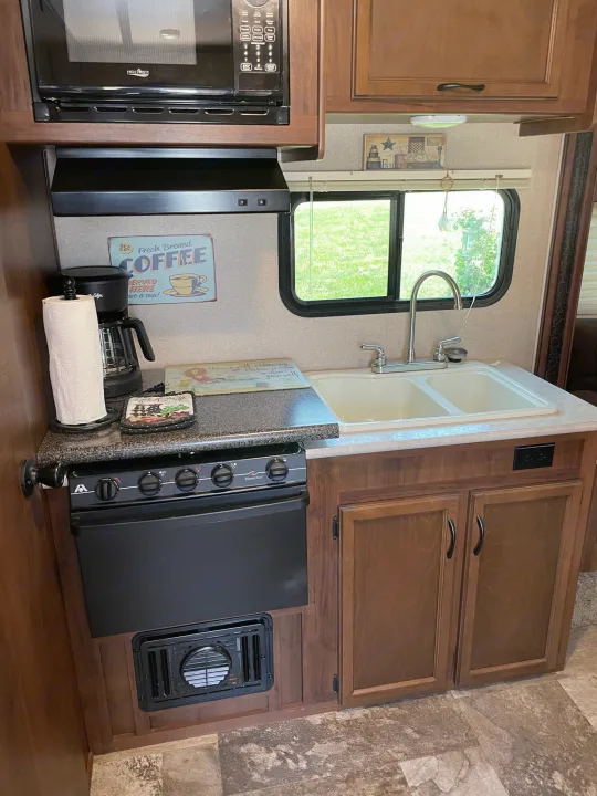 This RV rental's kitchen includes a microwave, oven, sink, and coffee maker, providing all comforts on the go.. Jayco Jay Feather Ultra Lite 2015