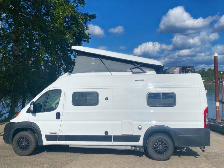 White pop-top camper van for RV rental, parked waterside.. Winnebago Winnebago 2021