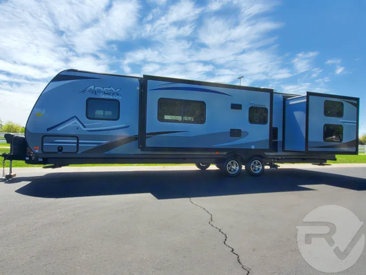 Spacious grey/blue Apex Ultra Lite travel trailer with slide-outs extended, ready for your rv rental.. Coachmen Apex 2021