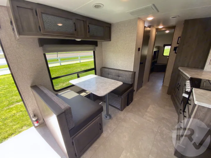 This RV rental offers a bright interior with a dinette, overhead storage, and kitchen, perfect for travel.. Coachmen Apex 2021