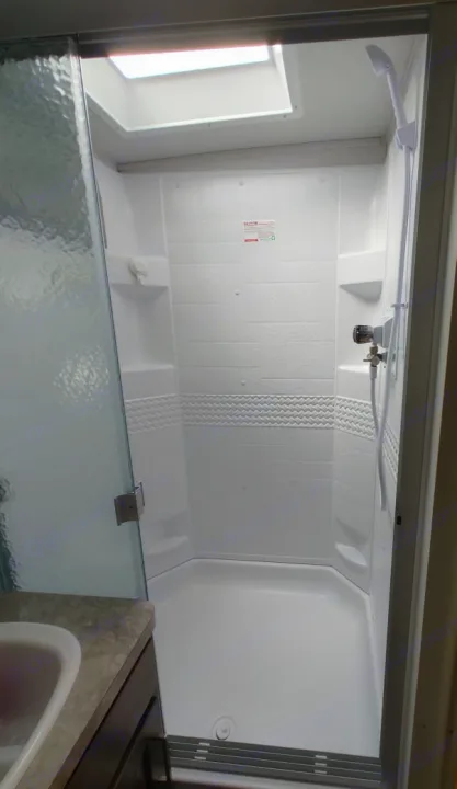 RV rental shower interior with a skylight and handheld sprayer, ready for your adventures.. Forest River Rockwood Ultra Lite 2021