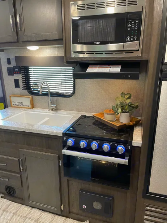 RV rental kitchen: Features a clean sink, microwave, Furrion oven/stove, and ample storage. Ready for your trips!. Jayco Jayflight 224bhw 2021