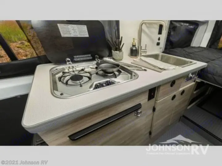 This RV rental offers a compact kitchen with a two-burner stove and sink, perfect for your travel and adventure cooking.. Winnebago Solis 2022