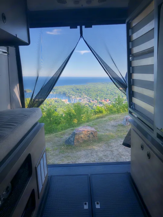 Experience breathtaking RV rental views! This camper van offers a panoramic outlook of a bustling bay, coastal town, and distant ocean.. Winnebago Solis 2022