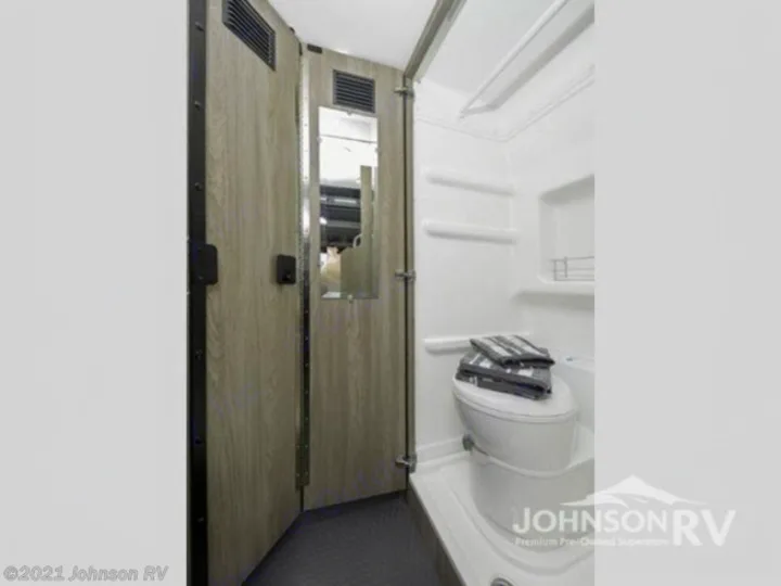 Explore this efficient RV rental bathroom with a compact shower, toilet, and mirrored entry door, perfect for your travels.. Winnebago Solis 2022