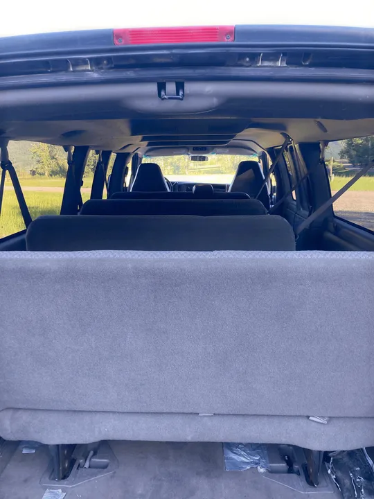 Spacious van interior from the rear, showing multiple seat rows, ideal for an RV rental road trip adventure.. Chevrolet Express 2007
