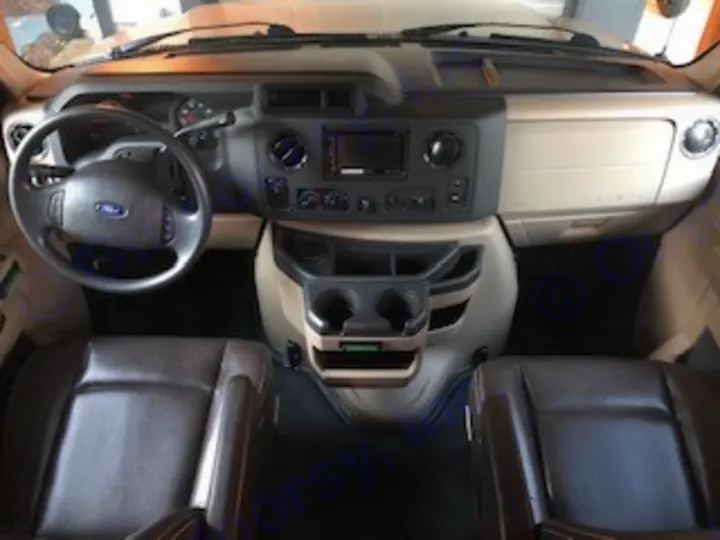 Inside your RV rental: a spacious cockpit with driver's seat, passenger seat, steering wheel, and dashboard controls for easy driving.. Forest River Other 2017
