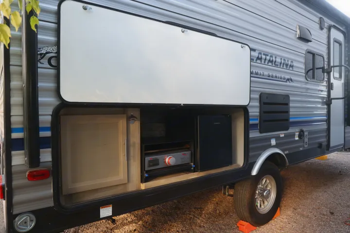 This RV rental, a Catalina Summit Series travel trailer, features a convenient outdoor kitchen with a griddle and mini-fridge.. Coachmen Catalina 2021