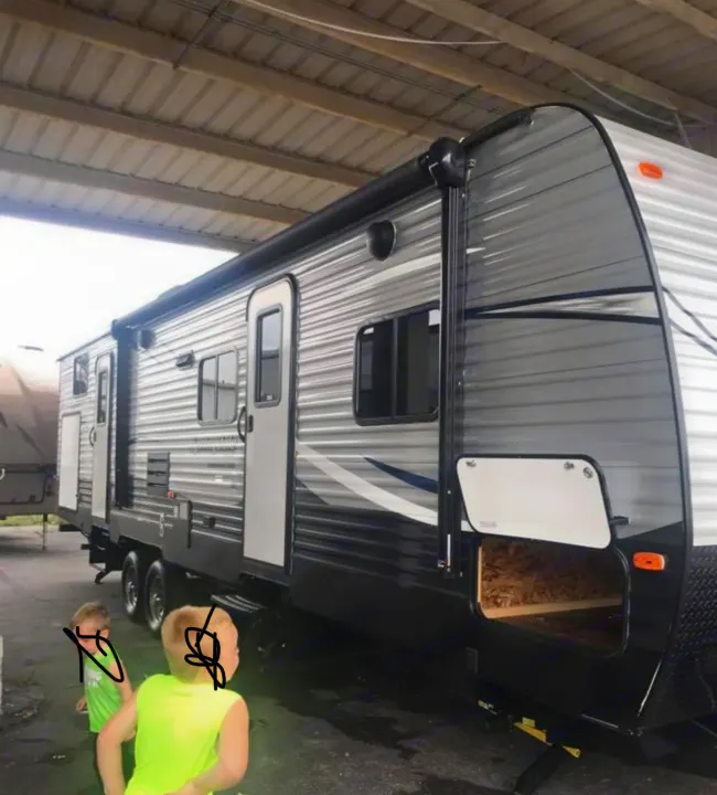 RV rental: Spacious gray travel trailer with an awning, perfect for family adventures. Two kids explore.. Keystone Summerland 2017