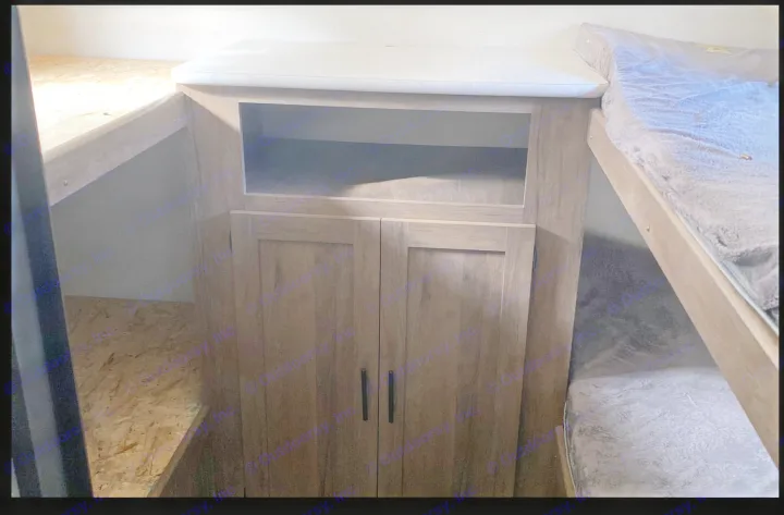 RV rental interior: upper & lower bunk beds, plus a storage cabinet with an open shelf & lower cupboard.. Forest River All American Sport 2020