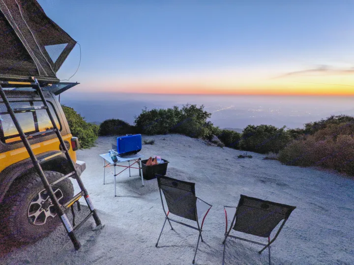 Enjoying a stunning mountain sunset with city lights from our rv rental, featuring a Jeep, rooftop tent, and camp setup.. Jeep Wrangler Unlimited Rubicon 2020