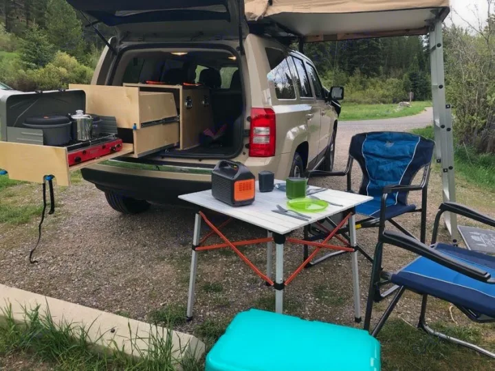 Car camping setup with SUV-integrated kitchen and outdoor dining for your next adventure. Perfect alternative to an RV rental.. Jeep Patriot 2016