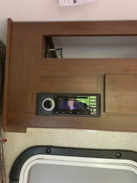 A Jensen multi-media entertainment system in an RV rental, integrated into a wooden cabinet, displaying 7:36 AM.. Forest River Sunseeker 2018