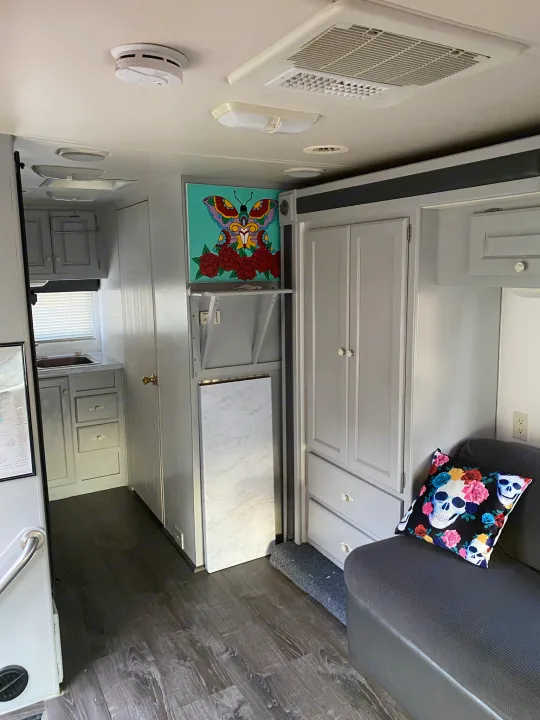This RV rental interior showcases a stylish living space with gray cabinetry, wood floors, and a functional kitchen.. Holiday Rambler Atlantis 2002