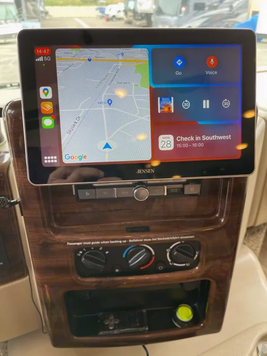RV rental dashboard featuring a Jensen touchscreen for navigation, audio, and calendar, plus climate controls.. Thor Motor Coach A.C.E 2020