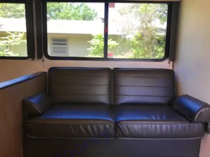 Comfortable RV rental interior with sofa seating and windows for a scenic view.. Keystone Hideout 2021