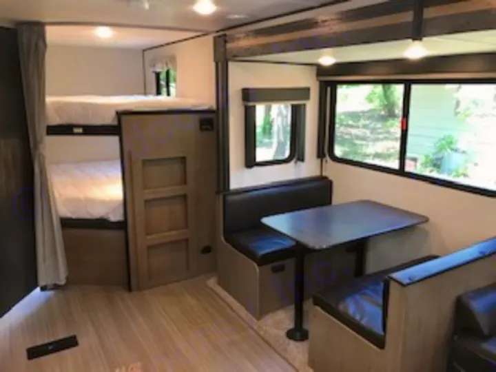 RV rental: Modern interior featuring bunk beds, a dinette, and ample living space for your next trip.. Keystone Hideout 2021