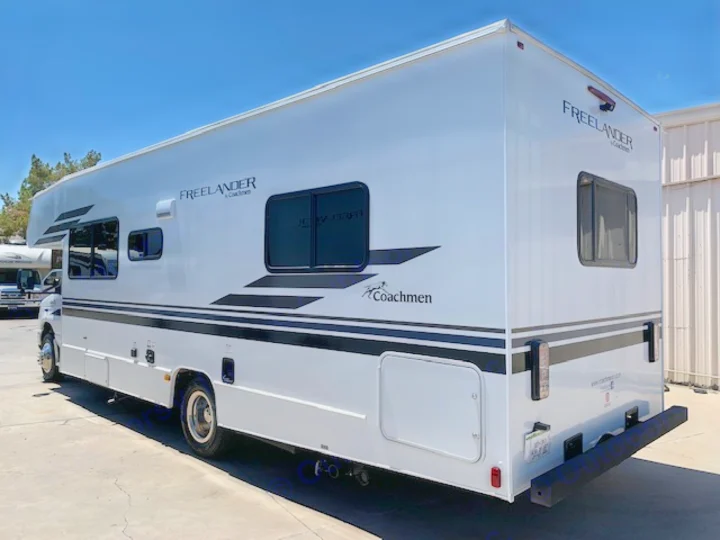 A large, white Coachmen Freelander RV, ideal for an rv rental, is parked outdoors on a sunny day.. Coachmen Freelander 2021