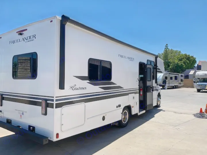 A sleek white Coachmen Freelander RV, ideal for rv rental, parked in a sunny lot with other RVs visible.. Coachmen Freelander 2021