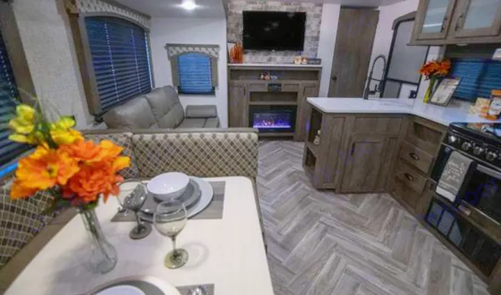 Inside a stylish RV rental, offering a comfortable living space, dining area, and well-equipped kitchen for your adventures.. Forest River Evo 2021