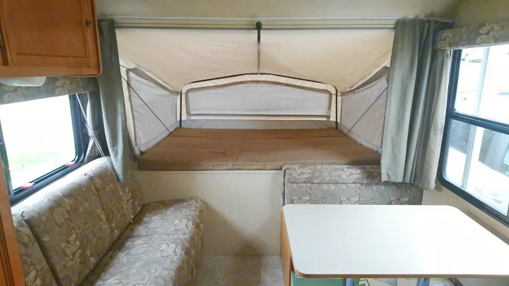 RV rental pop-up camper interior: Includes elevated bed, dinette, and large windows.. Starcraft Travel Star 2007