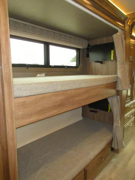 Inside an RV rental: double bunk beds with TVs, offering comfortable sleeping and entertainment options.. Jayco Seneca 2021