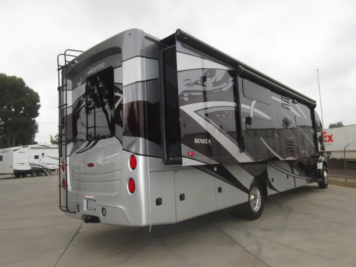 A large, luxurious Jayco Seneca motorhome, gray and black, with an extended slide-out, parked on a paved lot, great for rv rental.. Jayco Seneca 2021
