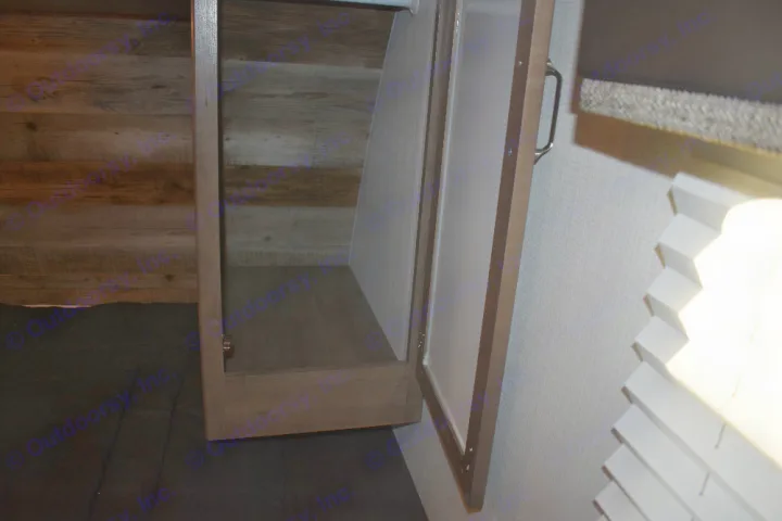 RV rental: Open cabinet with light interior for storage, next to wood-look walls and a bright window with pleated blinds.. Keystone Passport 2021