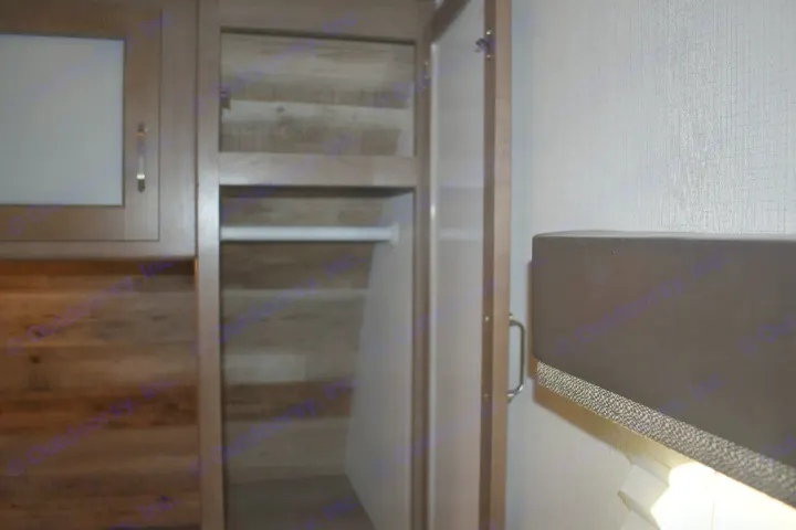 RV rental interior: Open wardrobe with hanging space & shelves, next to a window featuring blinds & soft lighting.. Keystone Passport 2021