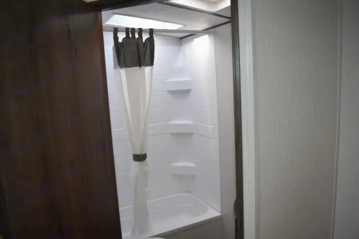 RV rental: Bright, clean shower/tub combo with curtain & shelves in a compact bathroom, perfect for travel.. Keystone Passport 2021