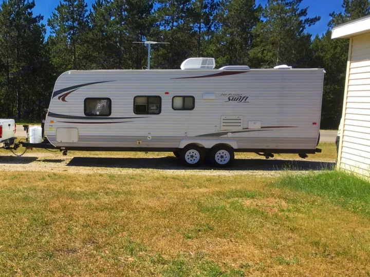 Ready for your next adventure! This Jayco Jay Flight Swift travel trailer is a great RV rental option, parked outdoors.. Jayco Jay Flight Swift 2012