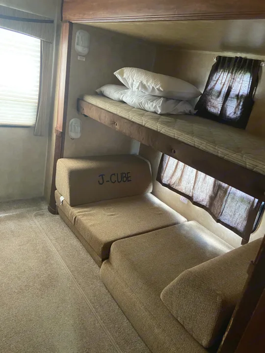 RV rental bunk beds with a J-Cube modular sofa/bed below, offering versatile sleeping and seating in a compact interior.. Jayco Camper Trailer- Eagle 2011