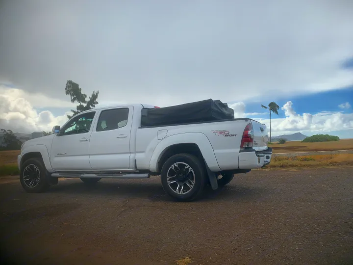 White Toyota Tacoma TRD Sport pickup with camping setup, a potential rv rental for outdoor adventures.. Toyota Tacoma 2009