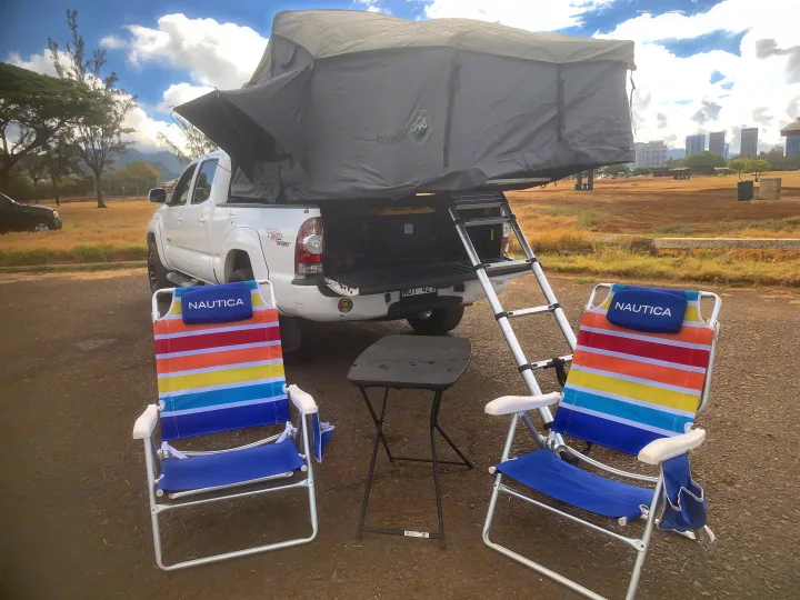 An RV rental for overland adventure: truck with rooftop tent, ladder, camp chairs, and table ready.. Toyota Tacoma 2009