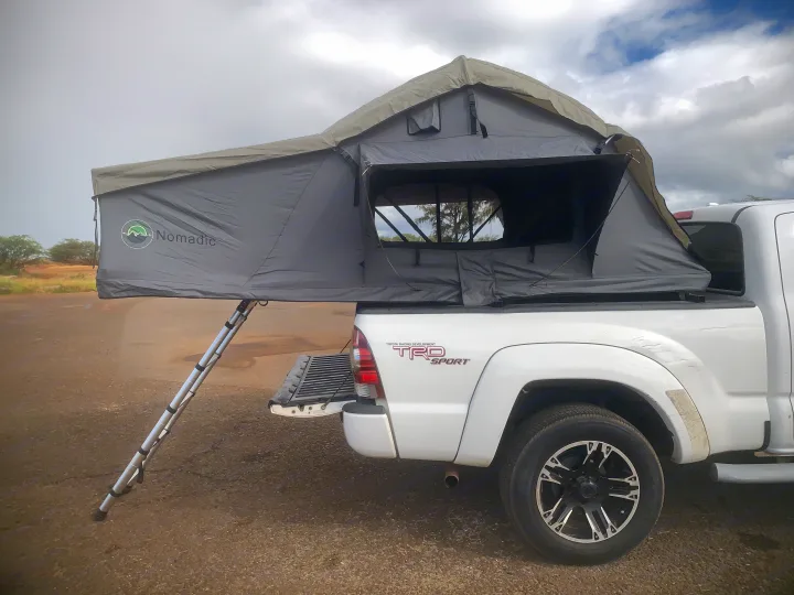 RV rental ready: White Toyota Tacoma with a deployed Nomadic rooftop tent for overlanding or camping adventures.. Toyota Tacoma 2009