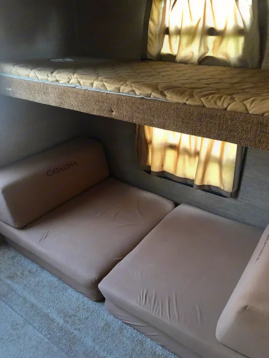 RV rental interior: upper bunk bed, lower convertible cushions (CATALINA brand), and sunny window area.. Forest River Coachmen Catalina 2016