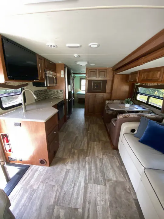 Spacious RV rental interior, featuring a modern kitchen, dinette, and sofa. Well-maintained for your comfortable travels.. Forest River Georgetown 2015