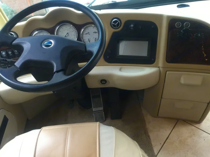 Navigate in comfort with this RV rental. Driver's cockpit featuring a steering wheel, modern dashboard, and ample controls.. Damon Tuscany 2008