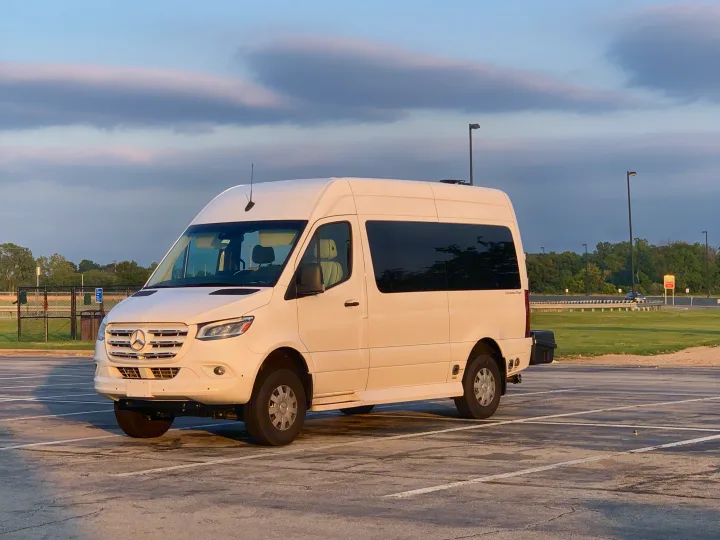 White Mercedes-Benz Sprinter van, appearing to be an rv rental, parked in a paved lot under a cloudy sky. It has tinted windows.. Mercedes-Benz 4x4 Sprinter mwb 2020