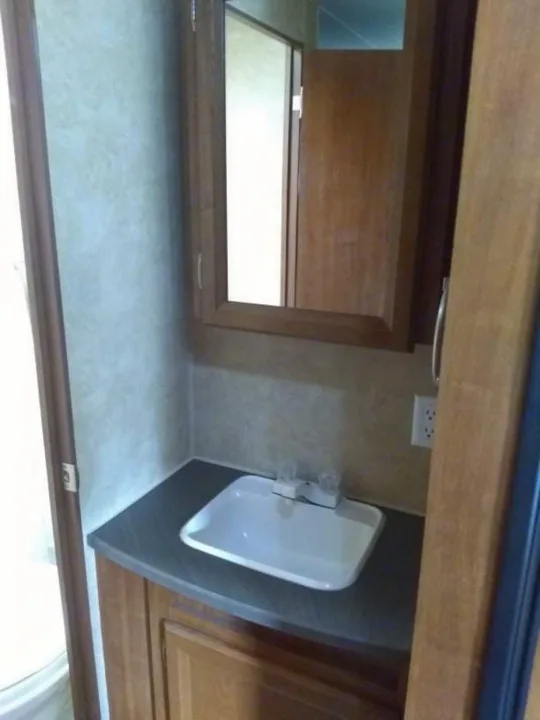 **RV rental** bathroom with compact vanity, sink, faucet, and mirrored cabinet, showcasing efficient use of space.. Jayco Jay Flight Swift 2012