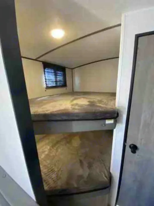 Inside an RV rental: comfortable bunk beds for extra sleeping space. Perfect for your next adventure.. Keystone Springdale 2021
